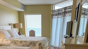 A bedroom with two beds, a dresser, a mirror, and a window with blinds. - Luxurious and Elegant, 4BR Ocean Front, Get away! Ocean Blue - Myrtle Beach, SC! (Myrtle Beach)