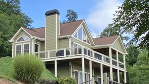 A large, two-story house with a wrap-around porch and a chimney.