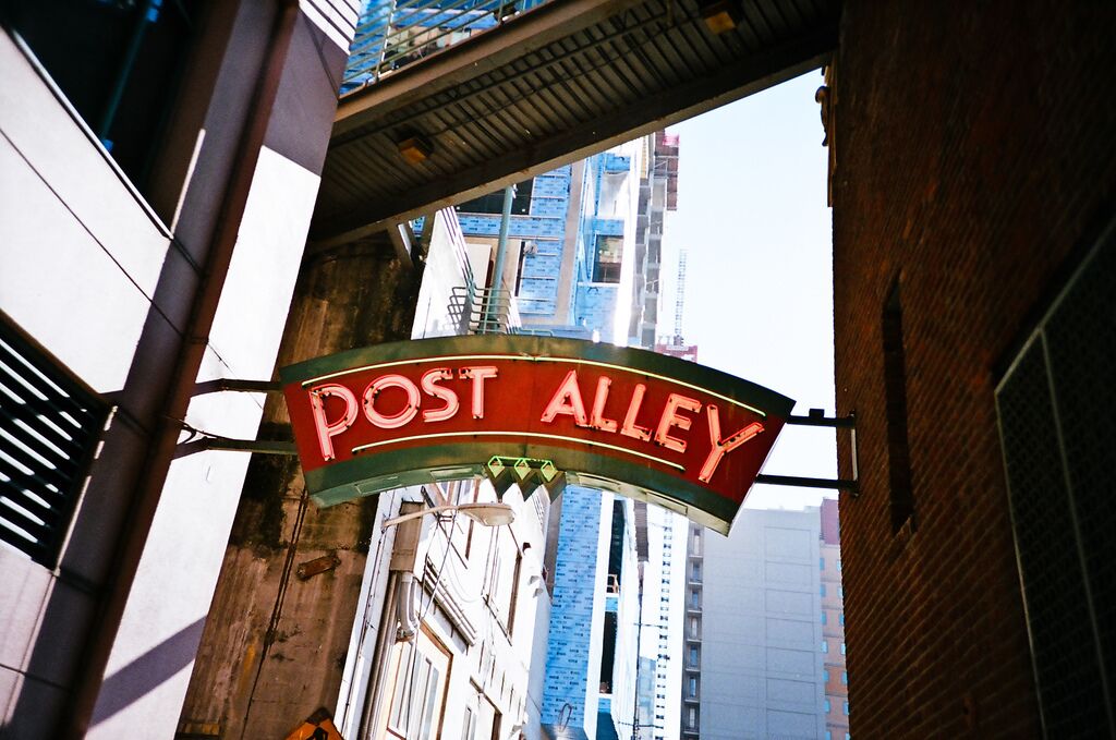 Una señal que dice 'POST ALLEY' en un entorno urbano.