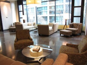 A spacious lobby with a modern design, featuring a mix of sofas and armchairs, a glass coffee table, and large windows offering a view of the cityscape. - Harbor Steps - 1 Blk to Pike Place Market, Waterfront - City Views! (Seattle)