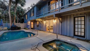 A two-story house with a pool, outdoor seating, and a covered patio area. - Peek of Blue – 2nd Row Sea Pines Home, Pool & Spa, Sleeps 17, 800 Ft to Beach (Hilton Head Island)