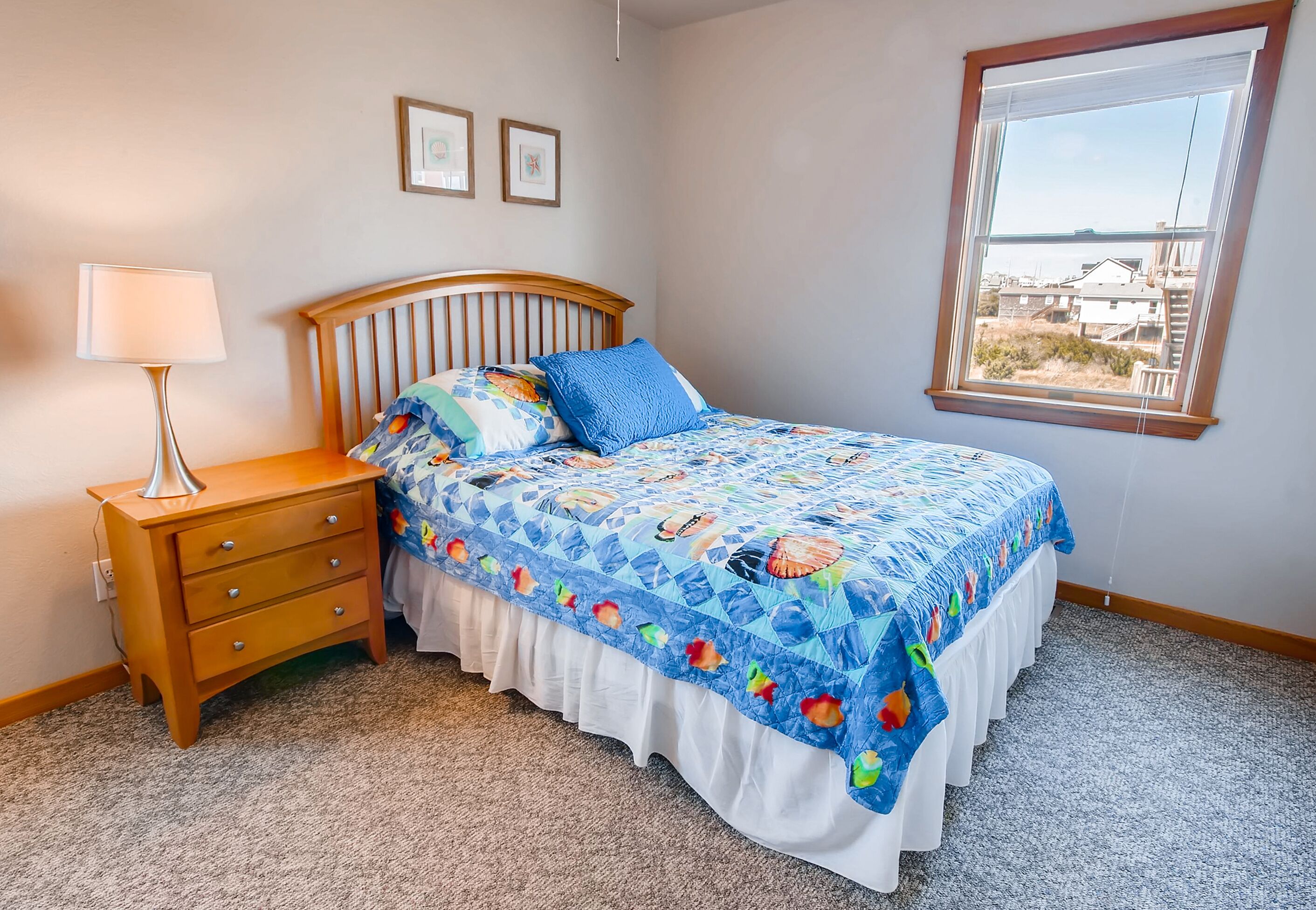 Une chambre à coucher avec un lit, une table de chevet, une lampe et une fenêtre donnant sur un beau paysage.