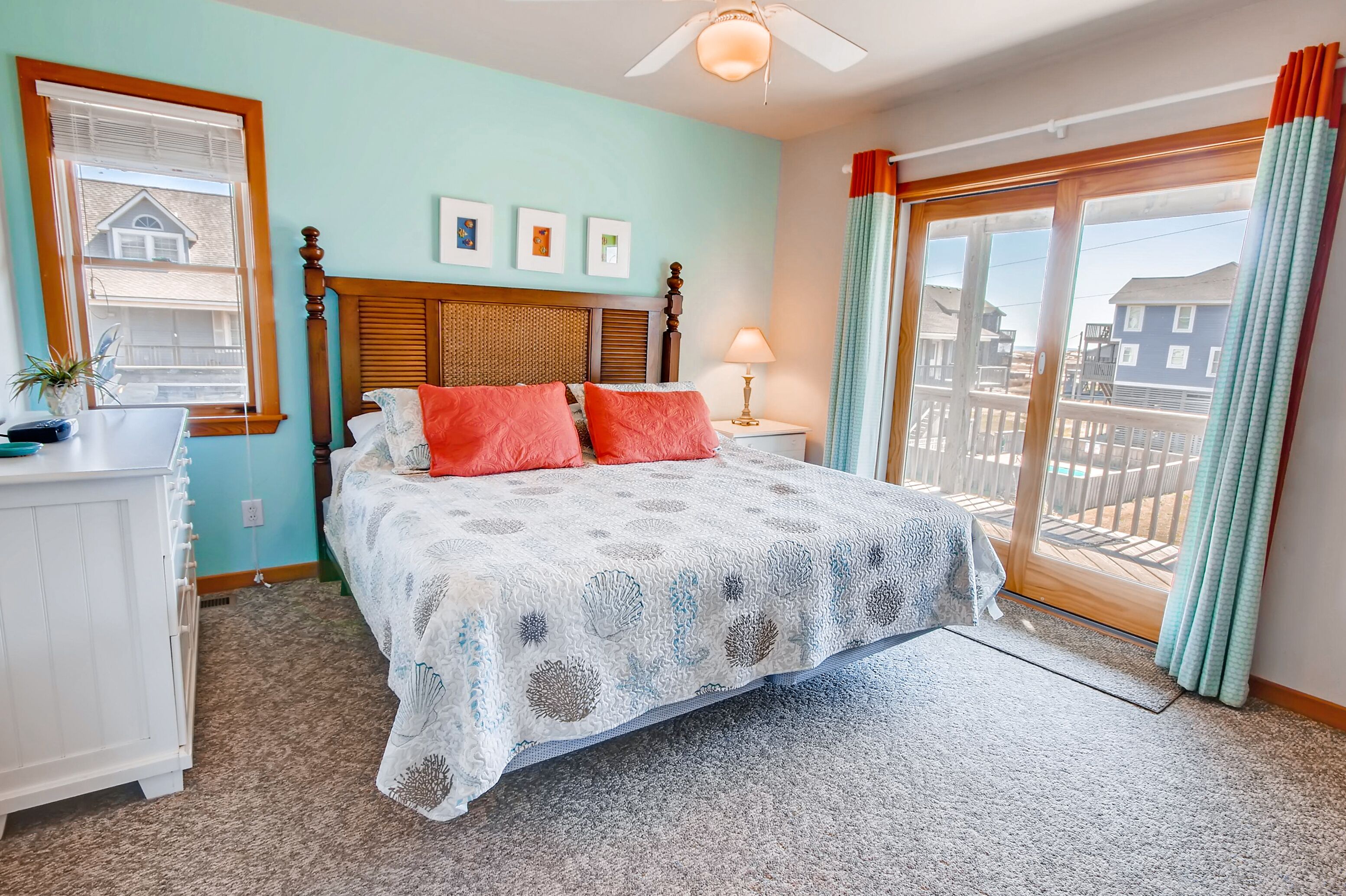 A bedroom with a bed, a nightstand, a lamp, a dresser, and a window with curtains.