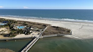 Una località balneare con spiaggia, molo e piscina.