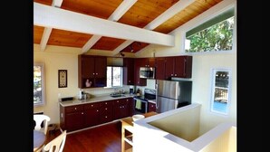 Une cuisine moderne avec des meubles en bois foncé, des appareils électroménagers en acier inoxydable et un grand îlot central.