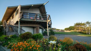 Una casa di legno con un portico e delle scale che conducono all'ingresso.