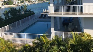 A two-story building with a balcony overlooking a marina and a swimming pool. - Grouper House: 4 Masters/6 BA, Pool/Dock, BoatRamp (Marathon)