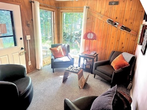 Een gezellige kamer met houten wanden, een open haard, een eettafel en uitzicht op de omgeving.