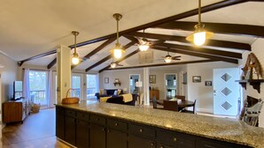 A spacious kitchen with dark cabinetry, a granite countertop, and pendant lighting.