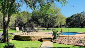 A backyard with a stone pathway, a swimming pool, and outdoor furniture. - 7-Acre Hill Country Haven w/ POOL-Guadalupe River (Bergheim)