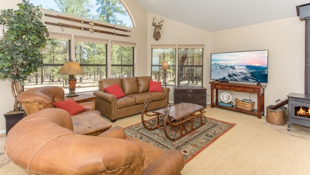 A spacious living room with leather sofas, a wooden coffee table, and a fireplace.