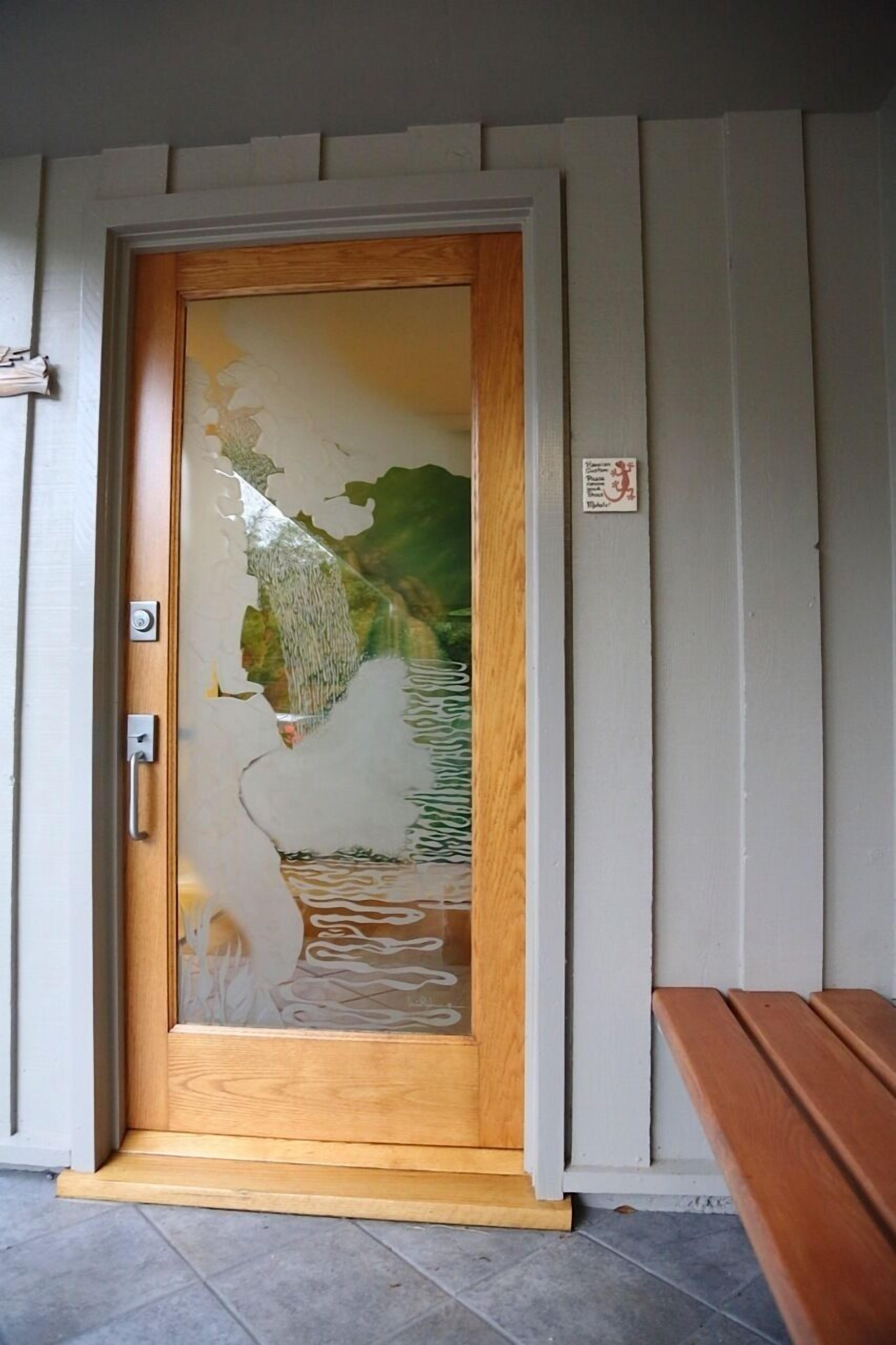 A wooden door with a glass panel featuring a landscape design.