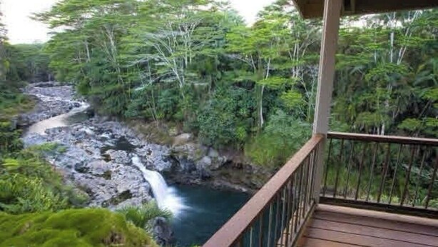 A wooden deck overlooking a rocky stream with lush greenery. - Gorgeous! The Waterfall Retreat At Reed's Island (Hilo)