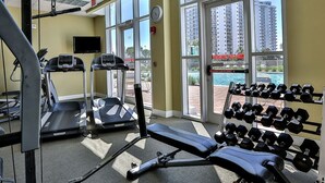A gym with treadmills, a bench press, and dumbbells.