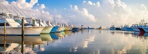 A marina with boats docked in a row, calm water reflecting the boats and sky. - Relax/Easy Walk to Beach MP 8- 3 Bedroom-2 Baths - Classic Beach Cottage (Kill Devil Hills)