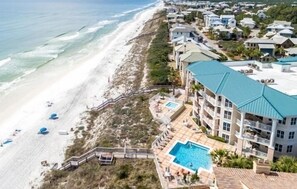 A beachfront hotel with a swimming pool, beach access, and multiple balconies.