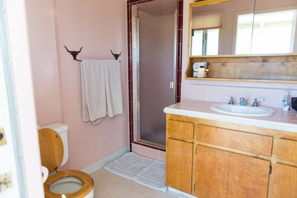 A bathroom with a wooden toilet, a sink, and a mirror.