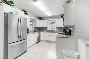 A modern kitchen with white cabinets, stainless steel appliances, and a marble countertop. - Waterfront in Crystal River! Scalloper's Heaven, Boaters Dream, see manatees (Crystal River)