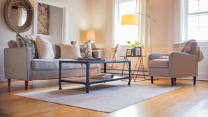 A living room with two sofas, a coffee table, a lamp, and a mirror on the wall. - The Rodney House (Lewes)