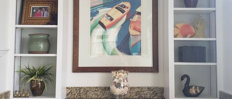 A kitchen with white cabinetry, a granite countertop, and a framed magazine cover on the wall.