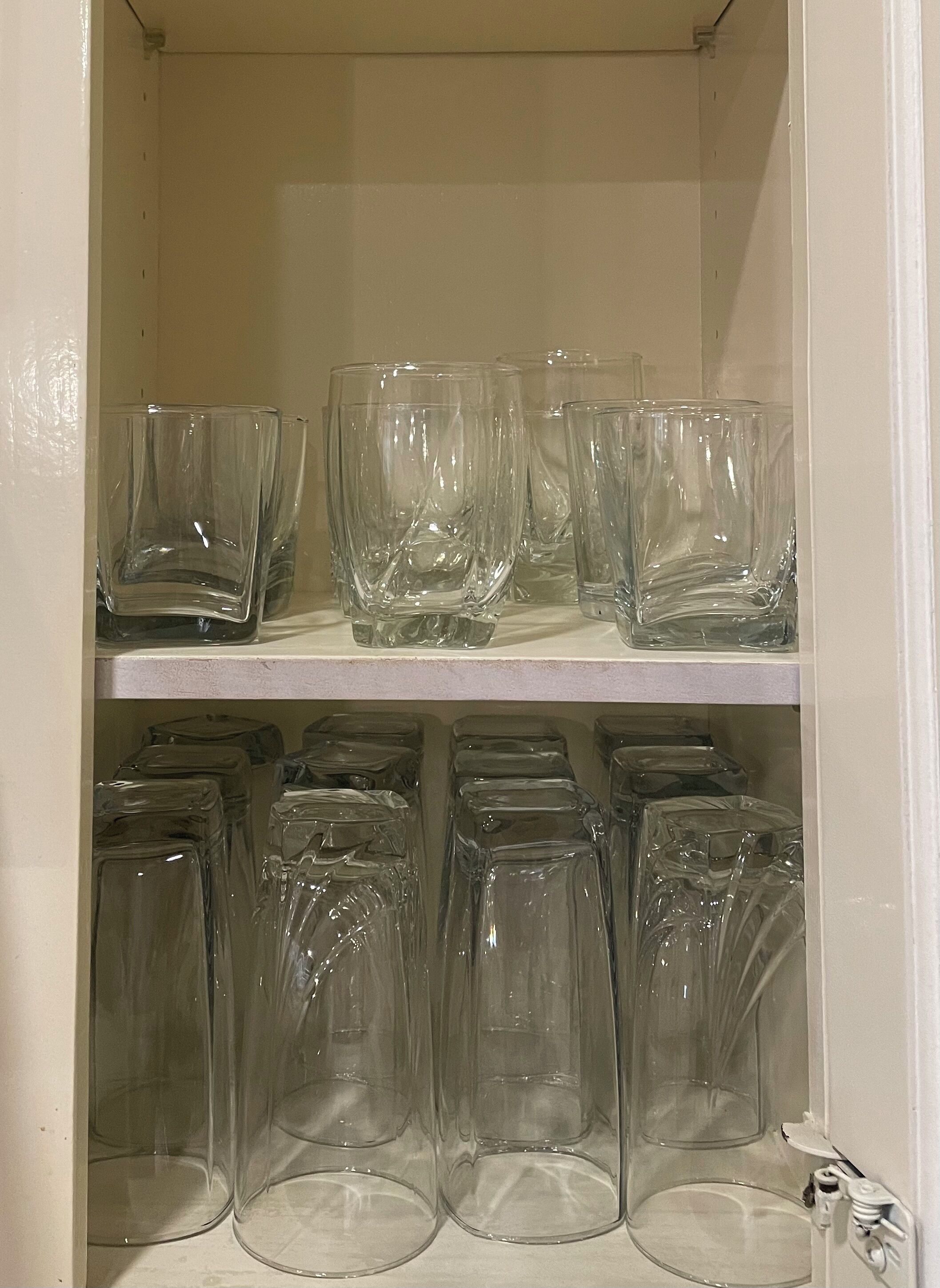 A storage area with shelves holding various glass containers.