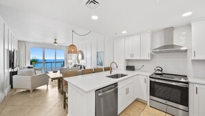 Una cocina moderna con armarios blancos, lavavajillas integrado y horno de acero inoxidable.
