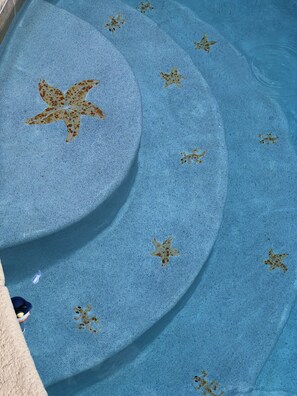 Una piscina con diseños de estrellas de mar en el suelo.