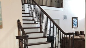 Una escalera con escalones de madera oscura y barandillas de metal negro.