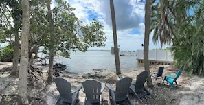 A beachside seating area with chairs and a view of the water.