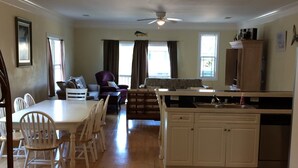 A spacious living area with a dining table and chairs, a sofa, and a kitchen area with a refrigerator and cabinets. - GCB exceptional oceanview-2 story, 4BR4.5BA Beach House, private pool, sleeps 14 (Murrells Inlet)