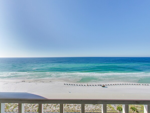 A beach view from a balcony with a railing, ocean, and clear sky. - Majestic Sun 909A. Beautiful Unit. Book today. Video Link! (Destin)