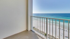 A balcony with a view of a beach and ocean.