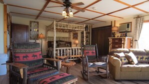 Un intérieur rustique avec des meubles en bois, un ventilateur de plafond et une cheminée.