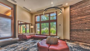 A modern hotel room with a large window, a curved ceiling light, and a wooden accent wall. - Perfect for Summer Balcony with Pool View Heart of Village (Park City)