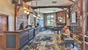 A lobby with a reception desk, seating area, and a large window providing a view of the outdoors. - Perfect for Summer Balcony with Pool View Heart of Village (Park City)