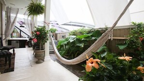A hammock in a covered outdoor area with potted plants and a staircase. - Fleur De Lis Mansion ,pool, near French Quarter & Superdome lic.Bnb  317134 (New Orleans)