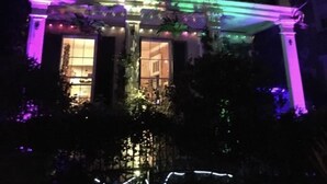A two-story building with a balcony and a covered entrance area, illuminated with purple and green lights. - Fleur De Lis Mansion ,pool, near French Quarter & Superdome lic.Bnb  317134 (New Orleans)
