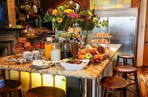 A breakfast bar with various food items, including pastries, fruits, and beverages.