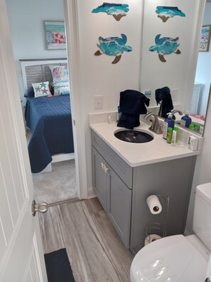 Een bad/douchecombinatie, handdoeken, toiletpapier