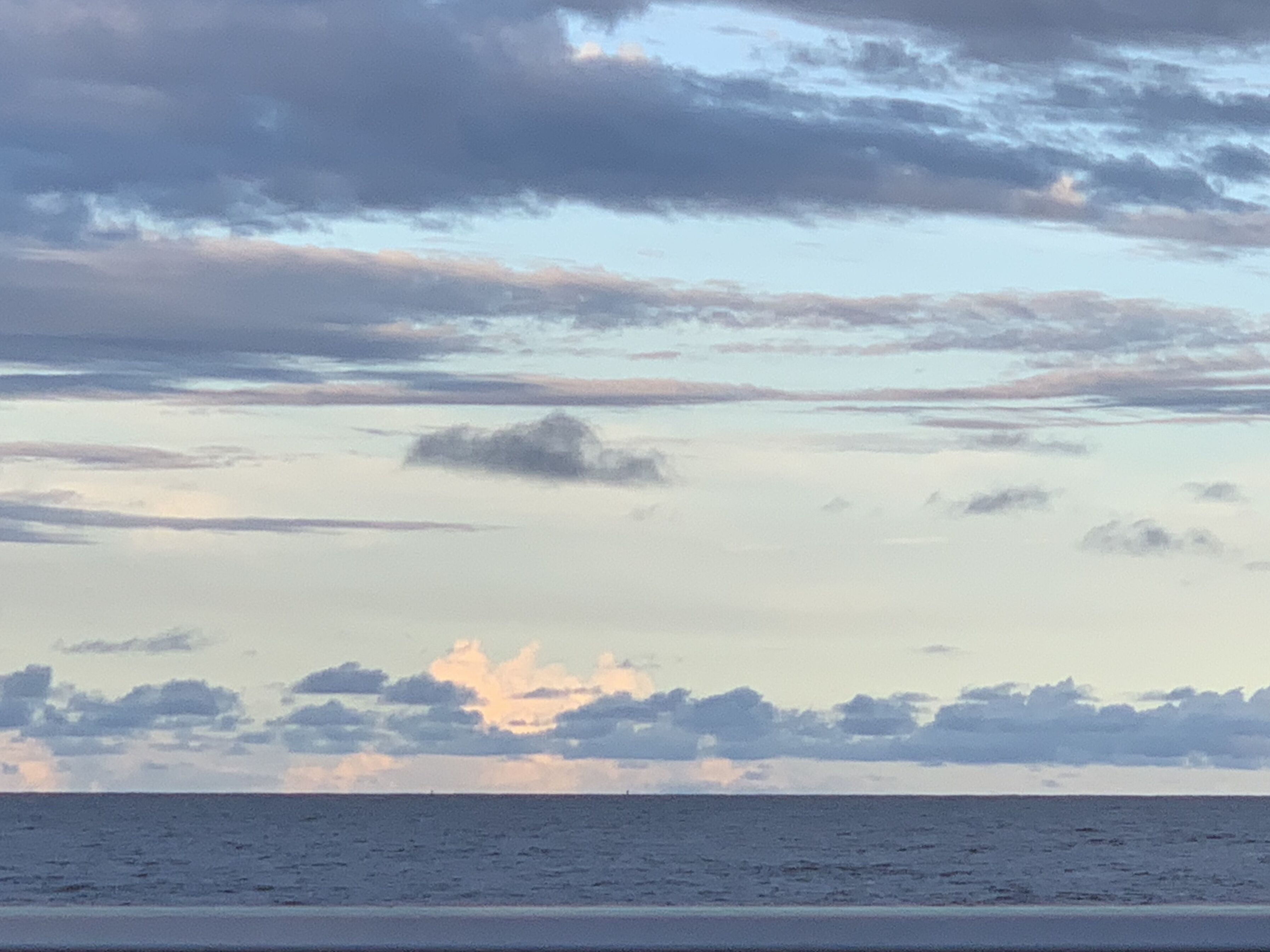 A beach with a view of the ocean and sky.