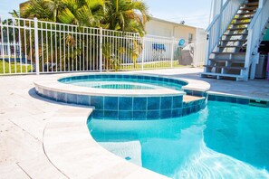 A swimming pool with a white fence and palm trees in the background. - A bit of Key West in New Port Richey: Bright Home w/ Pool & Boat Dock Access! (New Port Richey)