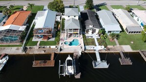An aerial view of a residential area with houses, a swimming pool, and a dock with boats. - A bit of Key West in New Port Richey: Bright Home w/ Pool & Boat Dock Access! (New Port Richey)