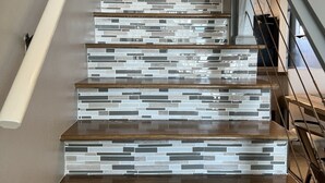 Una escalera de diseño moderno, que combina madera y baldosas de vidrio.