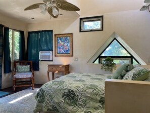 Une chambre à coucher comprenant un lit, une chaise, un bureau, une fenêtre et un ventilateur de plafond.