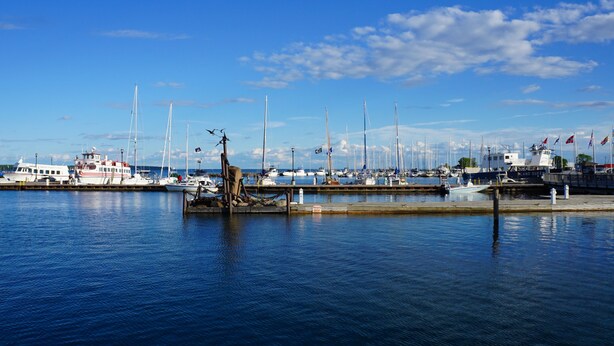 A marina with various boats docked, a prominent statue in the foreground, and a clear blue sky. - 4 Bed 2 Bath Escape in the Woods. 10 minutes to the beach! (La Pointe)