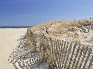 A sandy beach with a wooden fence and dry grass. - Beautiful and Spacious Ocean Block Condo!!!  Amazing Bay and Ocean Views!!! (Ocean City)