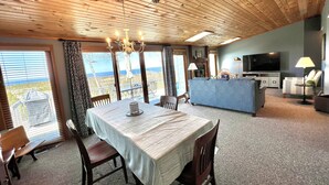 Un amplio espacio de sala con una mesa de comedor, sillas, un sofá y un televisor.