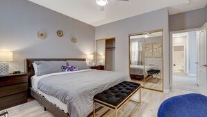 A bedroom with a bed, bedside table, bench, and a ceiling fan. - Chic Single Story 3br House Close To Strip & Airport (Las Vegas)