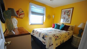 Un dormitorio con una cama, una ventana, una lámpara y un cuadro en la pared.