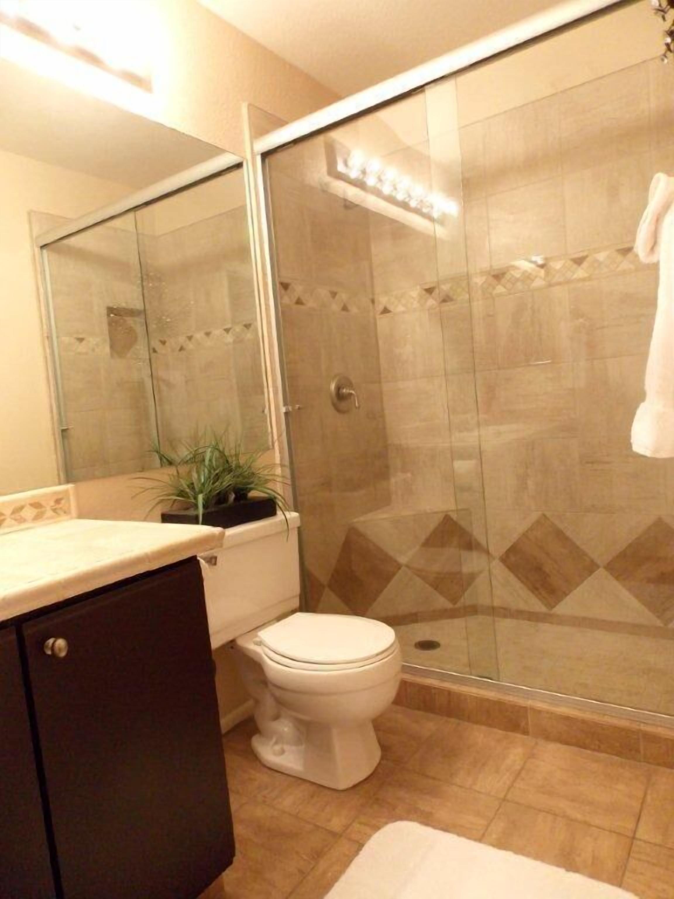 Ein Badezimmer mit Toilette, einer Duschkabine, einem Waschbecken und einem Schrank.